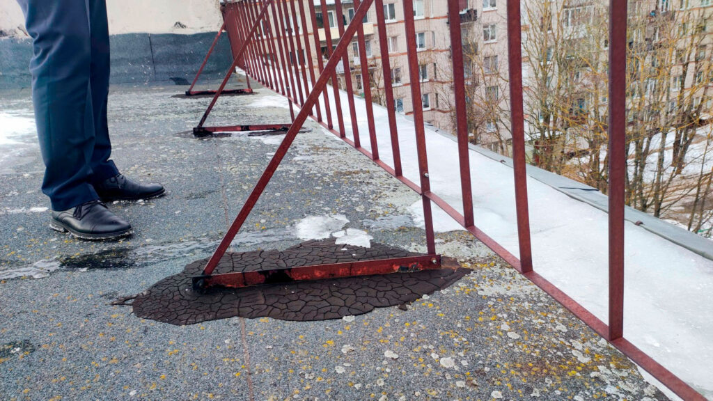 Крупный план узла ограждения на кровле с дефектами примыкания