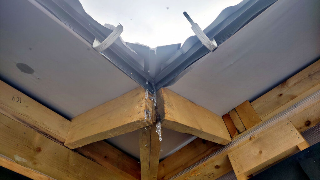 Наледь в узле кровли и следы неправильного водоотвода при приёмке дома