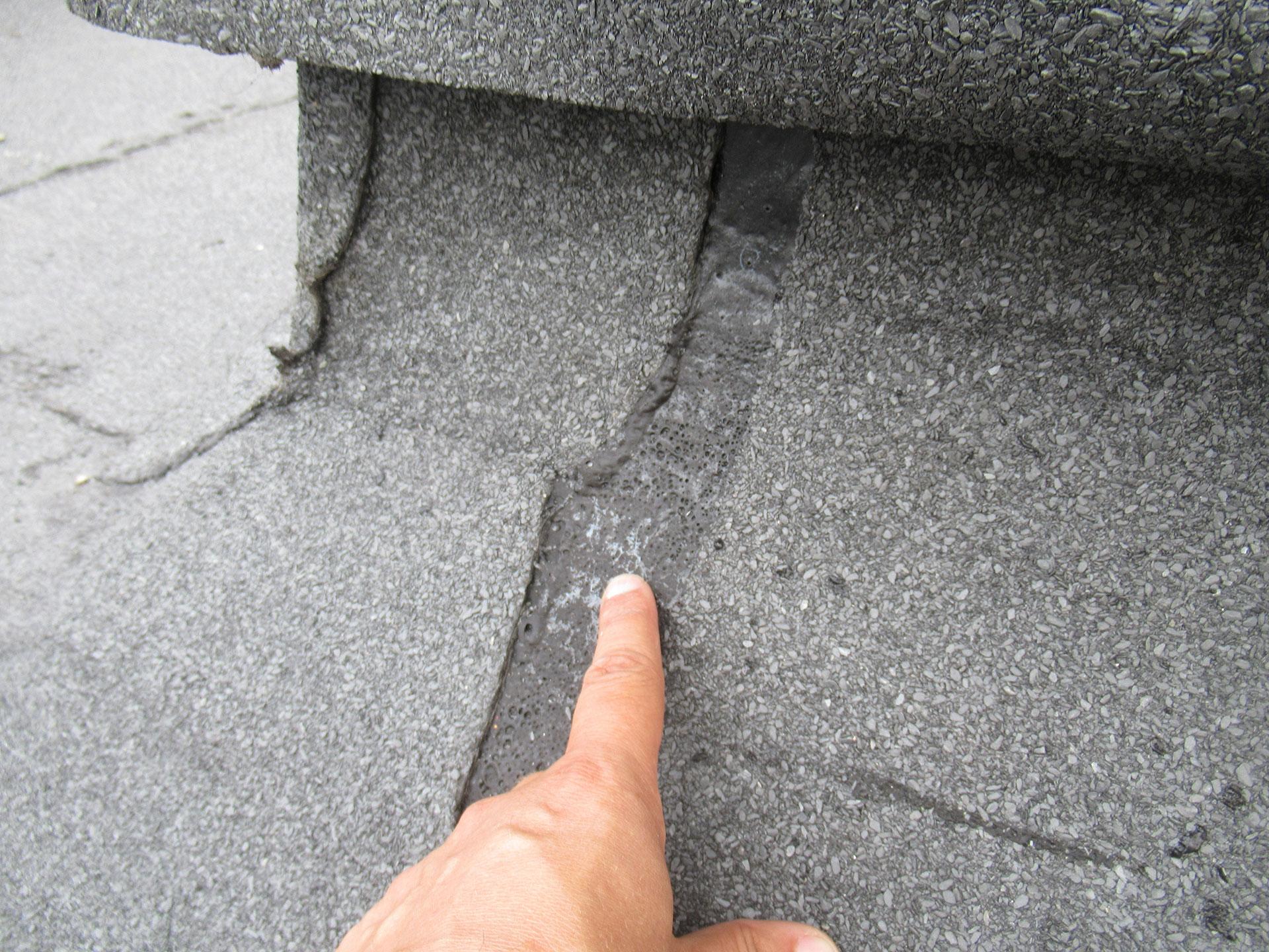 Дефект рулонной кровли: вздутия и непровар в зоне стыка (палец указывает на участок)