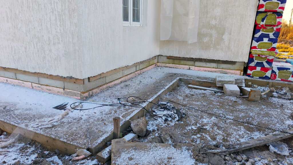 Общий вид дома с недоделанным цоколем, примыканиями и незавершённой отмосткой при осмотре перед приёмкой