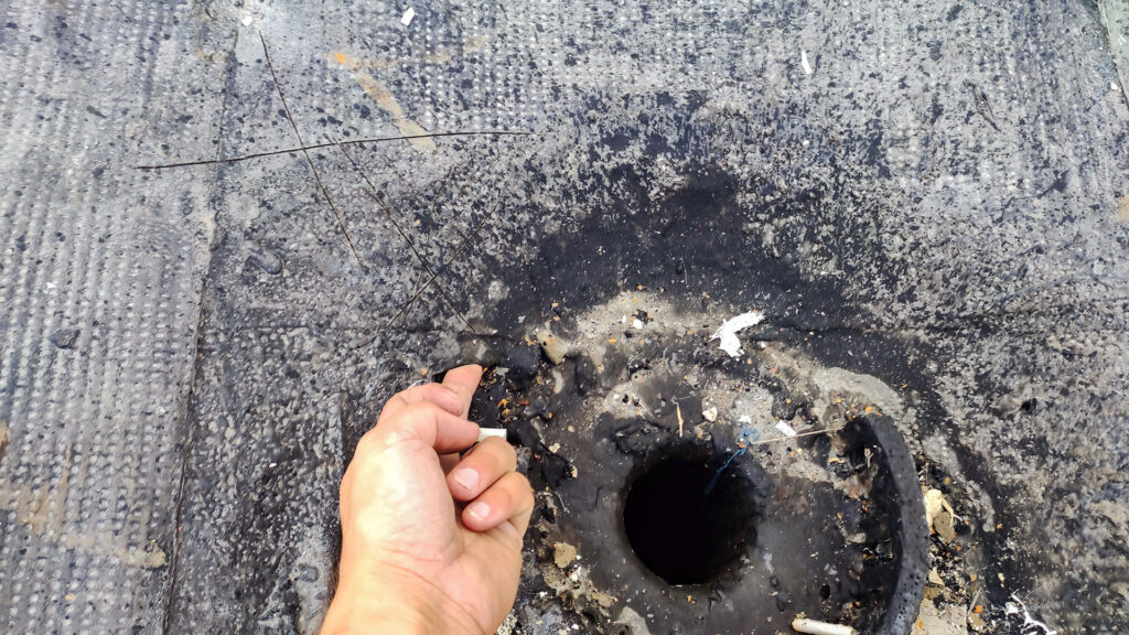 Поврежденное водосточное отверстие на мягкой кровле при осмотре узла