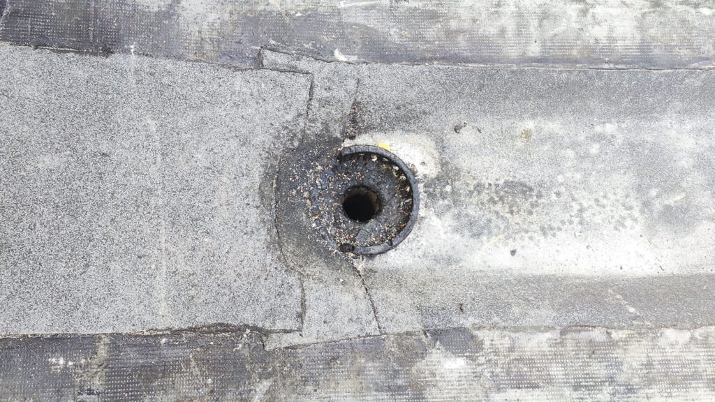 Водоотводная воронка на плоской кровле с дефектами узла и прилегающего покрытия