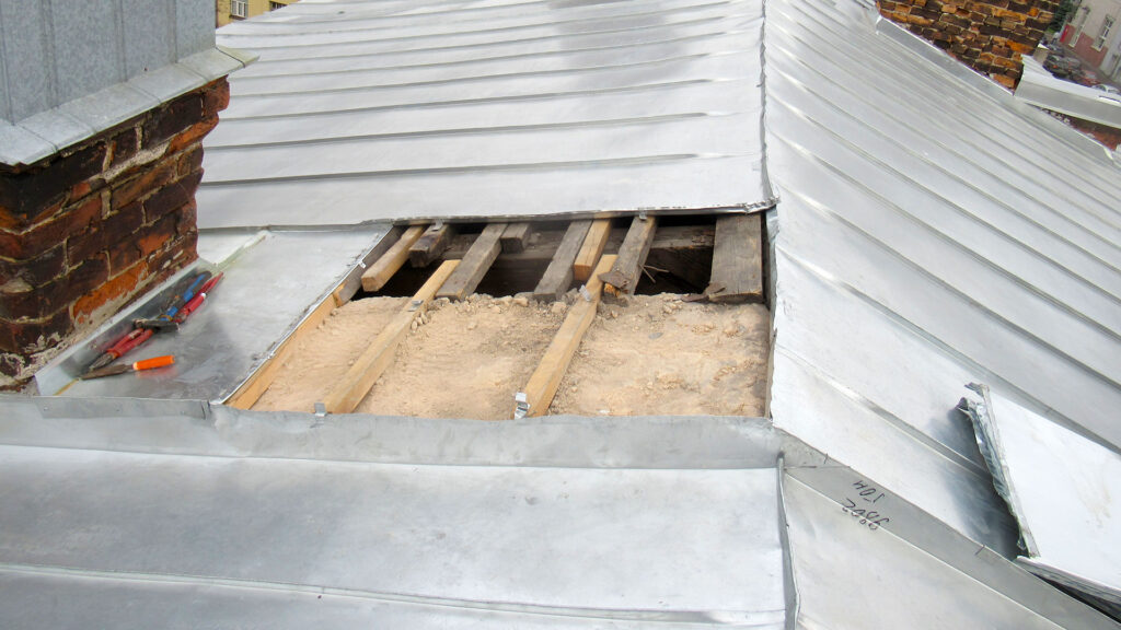 Вскрытие участка металлической кровли при обследовании причины протечки