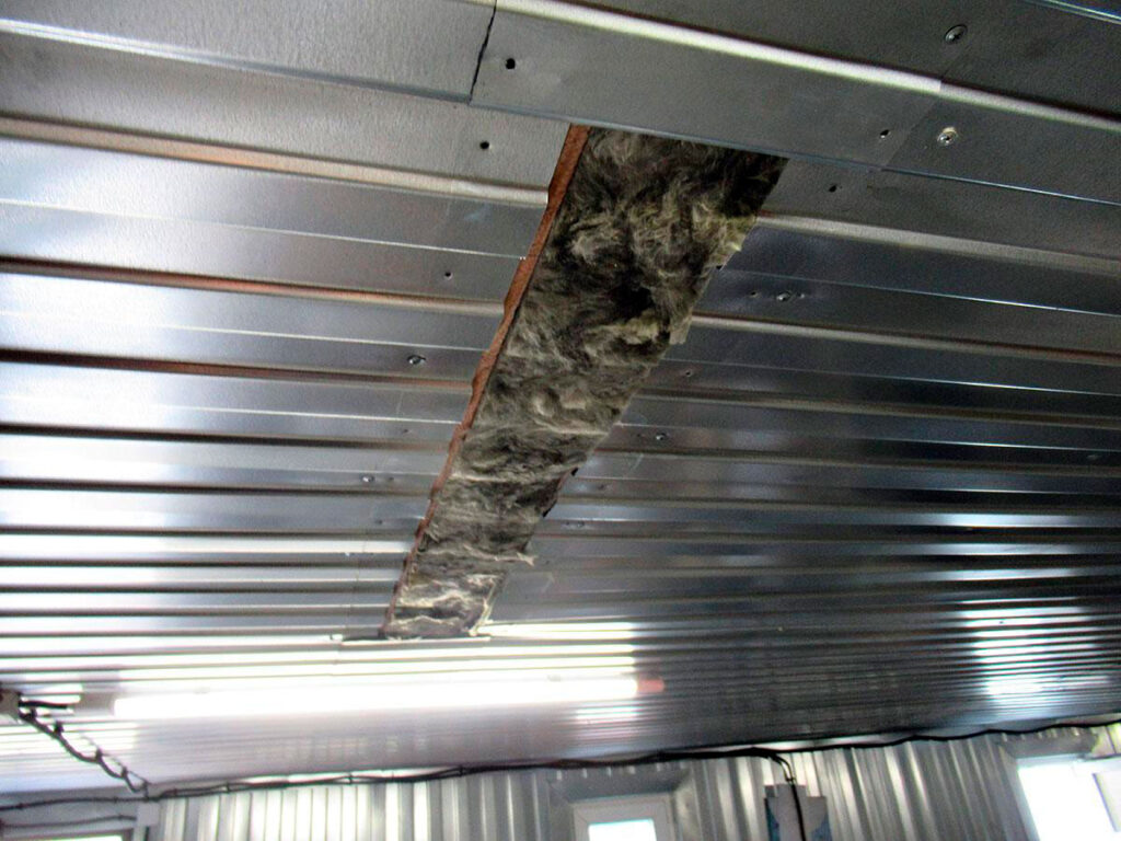 Вскрытый участок потолка с утеплителем при поиске скрытого пути воды